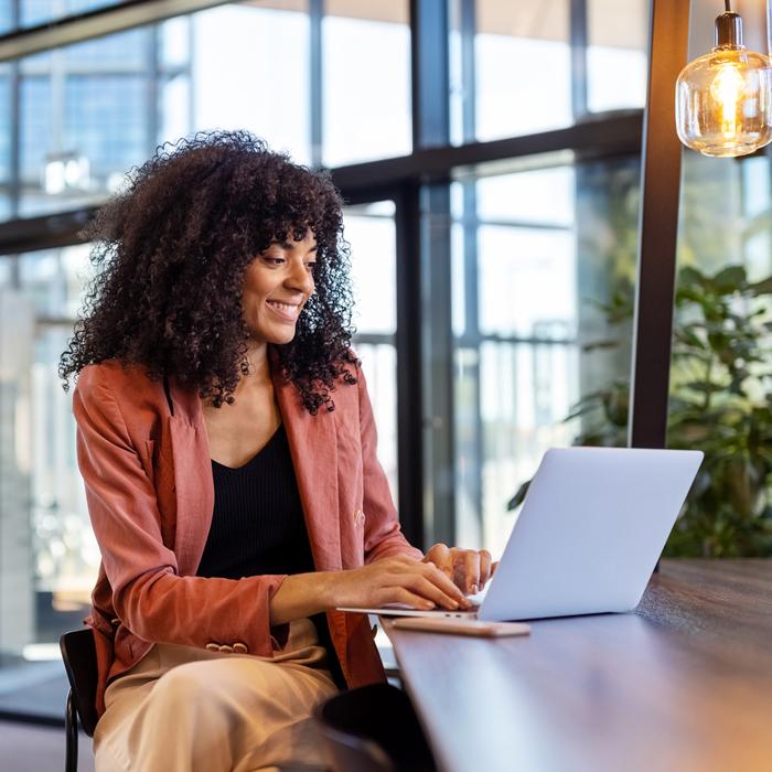 A woman using the Patelco certificate renewal feature on her laptop